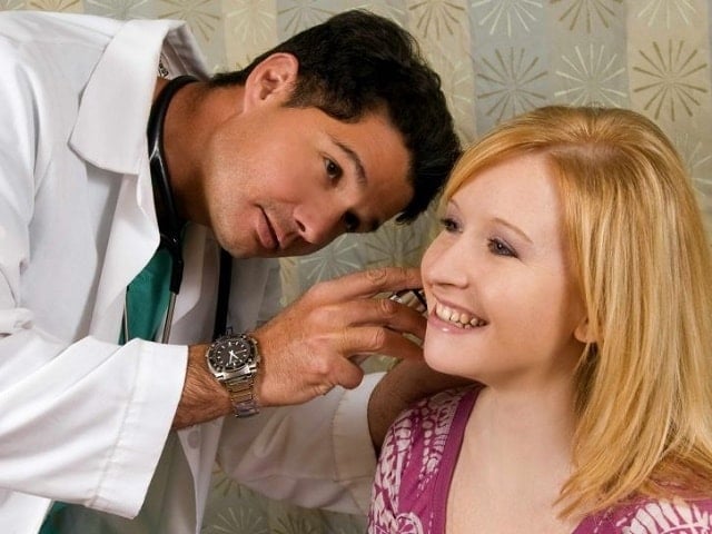 Physician Conducting An Examination Of A Female Patients Left Ear Using An Otoscope 725x544 Min