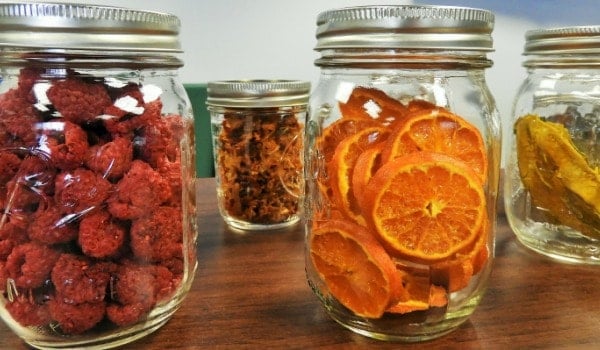 Jars of dehydrated orange slices and raspberries.