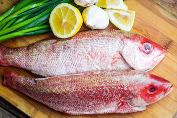 Whole red snapper on a chopping board