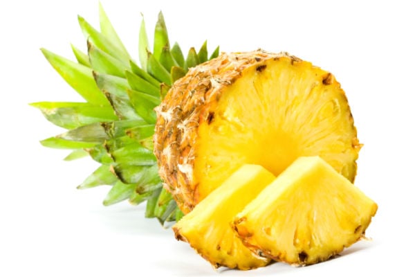 fresh pineapple slices with half a fruit