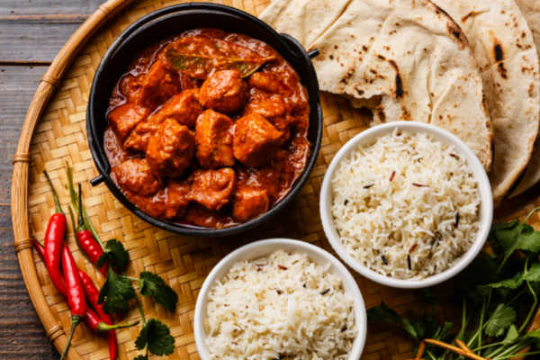 Chicken tikka masala in a bowl with rice and naan.