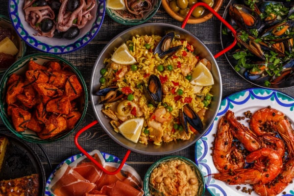 A pan of paella surrounded by Spanish tapas