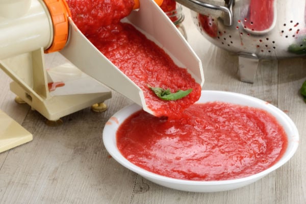 A tomato press processing tomatoes