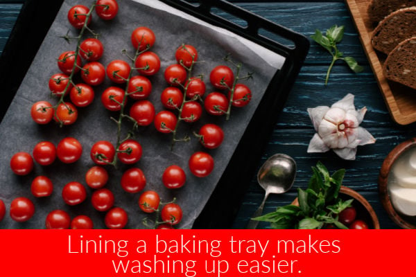 Tomatoes on a lined baking tray ready to bake