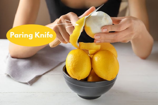 Using a knife to peel a lemon