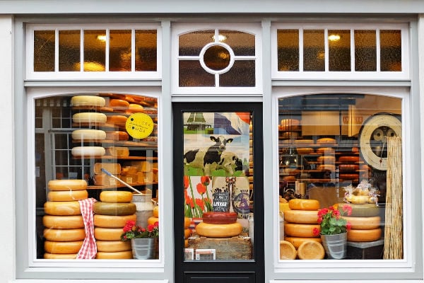 Shop frontage of a cheese shop with stacks of gouda