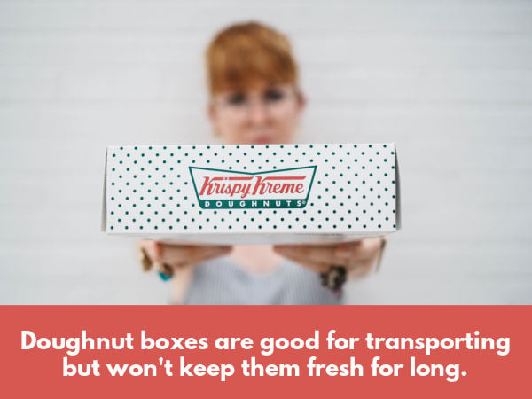 A lady holding Krispy Kreme doughnuts in a box