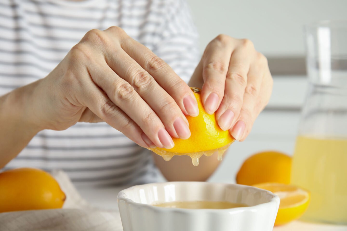 woman squeezing lemon juice into a bowl