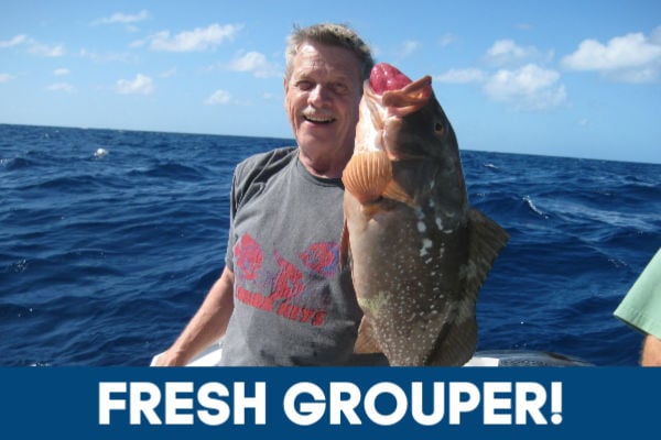 Fisherman holding fresh grouper.