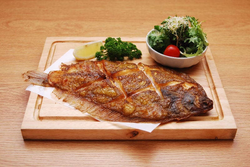 Cooked flounder on a board