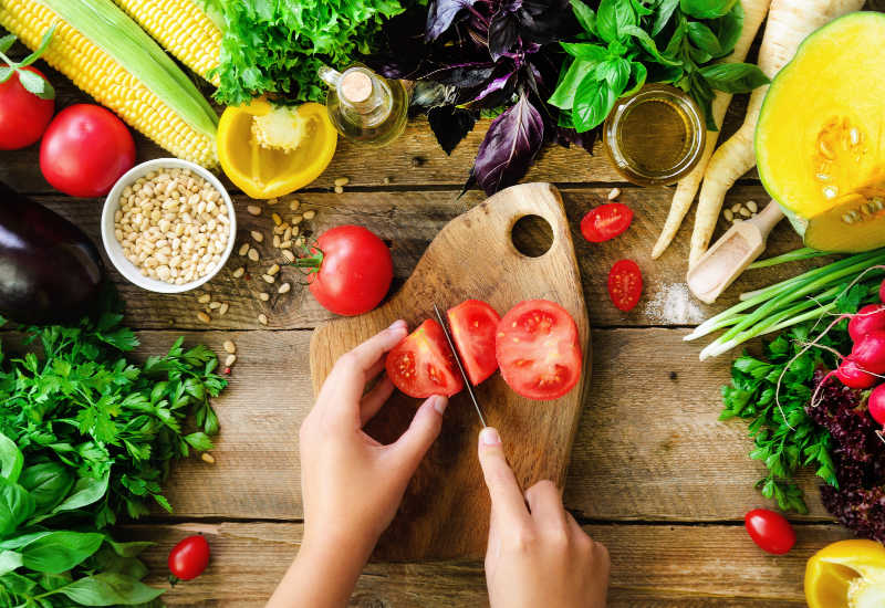 Slicing tomatoes on a chopping board.