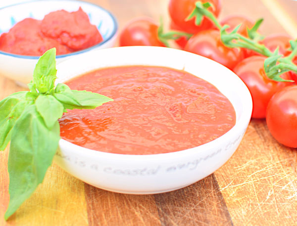 A bowl of tomato sauce with a basil garnish