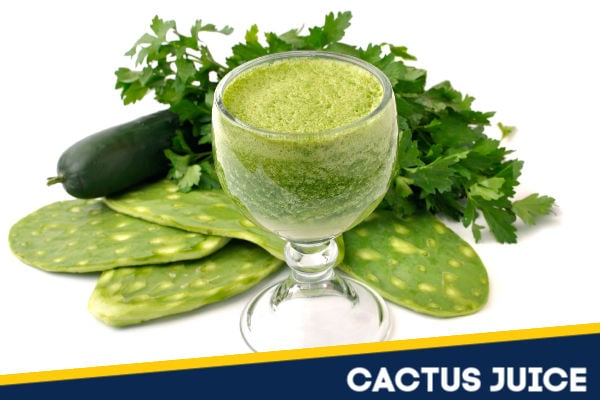 A glass of cactus juice next to fresh nopales