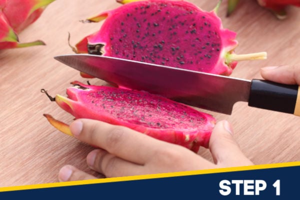 Slicing open the dragonfruit lengthways.