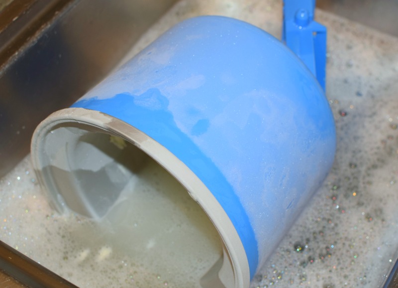 A bowl being washed in hot soapy water