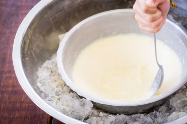 Ice cream mixture in a bowl surrounded by ice and salt