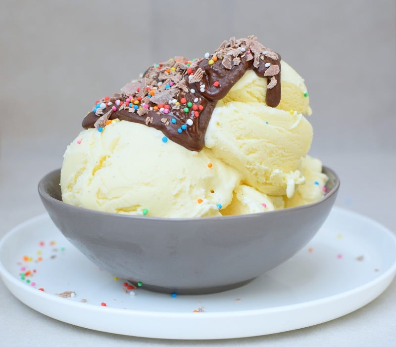 A bowl of vanilla ice cream covered in chocolate sauce