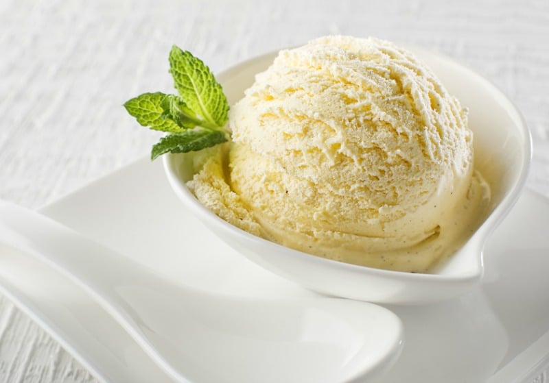 A scoop of vanilla ice cream with a garnish of mint