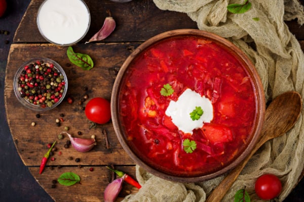 Vibrant red borscht soup with a garnish of sour cream