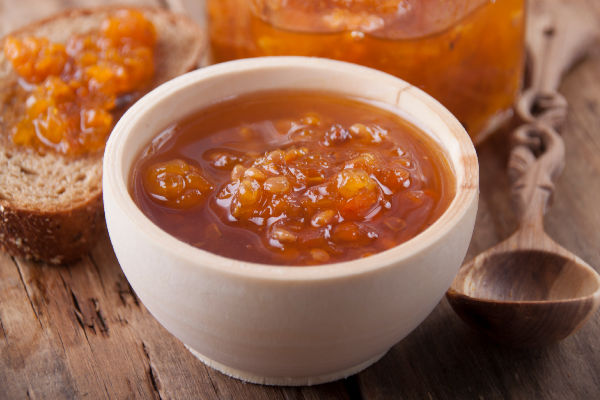 Cloudberry jam in a bowl next to bread
