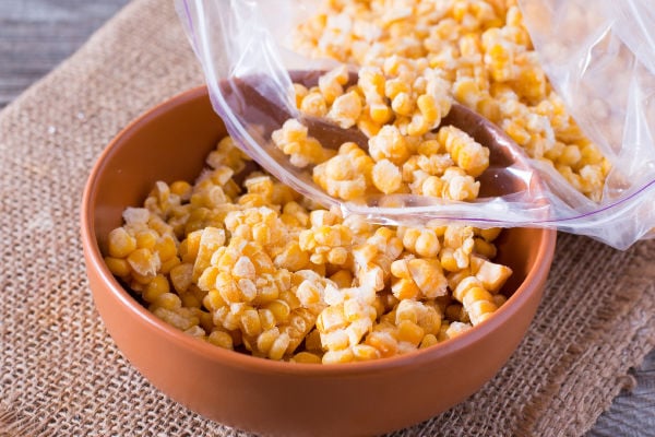 Pouring frozen corn into a bowl