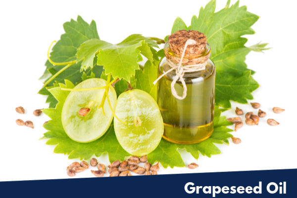 A bottle of grapeseed oil next to fresh grapes
