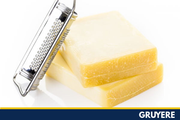 Blocks of gruyere and a grater