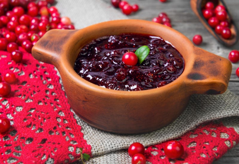 A bowl of lingonberry jam and fresh lingonberries