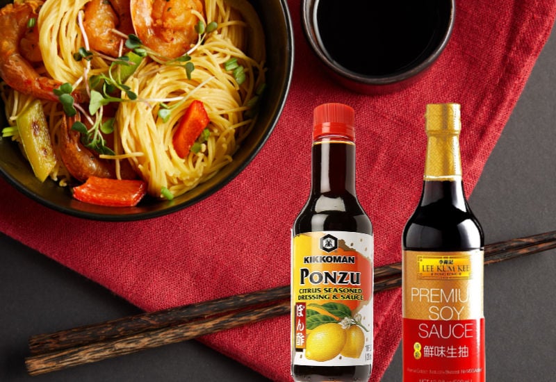 An Asian dish next to a bottle of ponzu and soy
