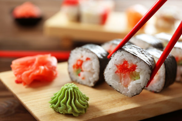 Chop sticks holding a piece of sushi