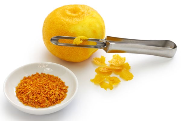 A small bowl of yuzu zest and a peeler.