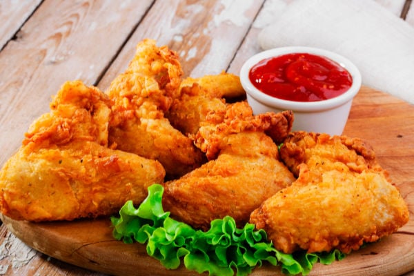 Fried chicken and dipping sauce on a board