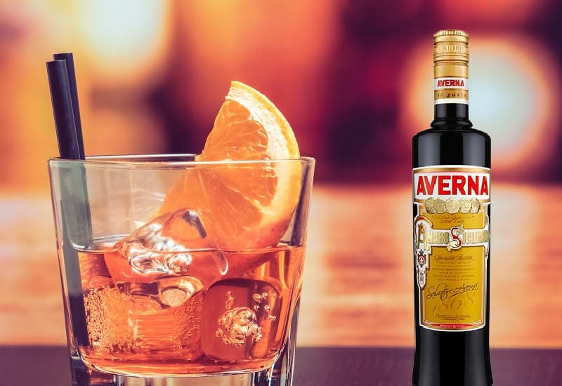 A cocktail next to a bottle of Averna Amaro
