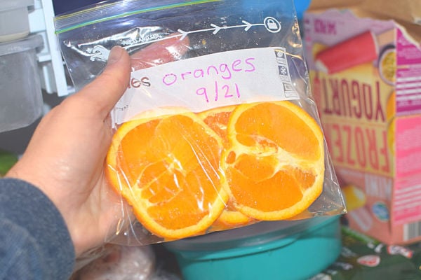 Placing a bag of oranges in the freezer