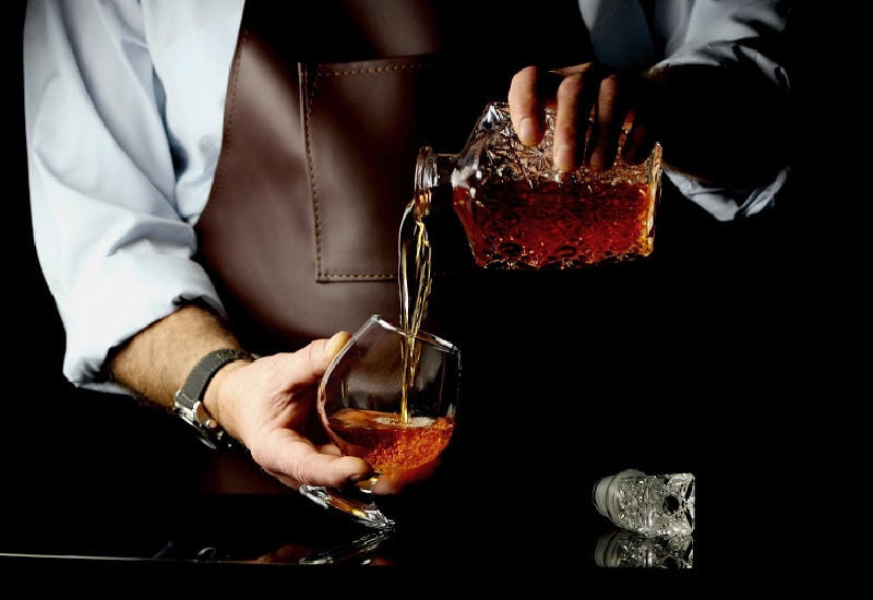 A man pouring cognac into a glass