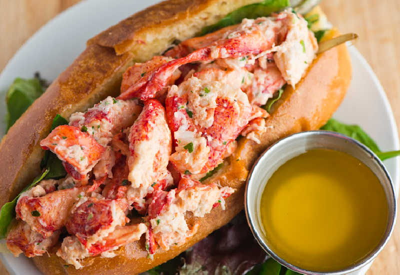 Lobster Roll next to a bowl of melted butter