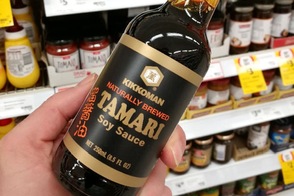 Holding a bottle of tamari sauce