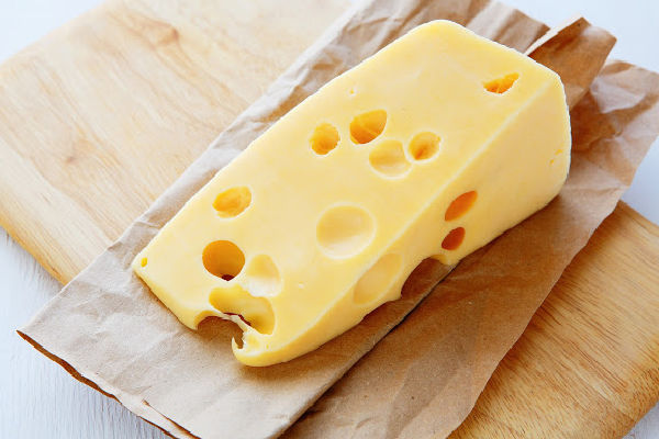 A wedge of gruyere on a paper bag