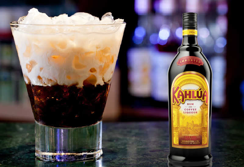 Coffee liqueur next to a White Russian cocktail