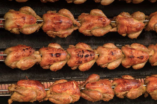 Multiple rotisserie chickens cooking