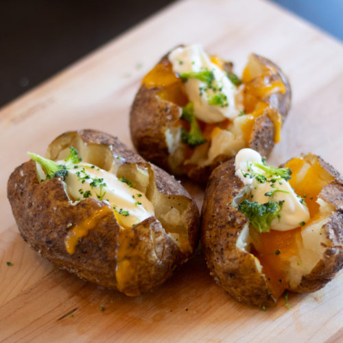 Air fried baked potato topped with cheese, sour cream and broccoli