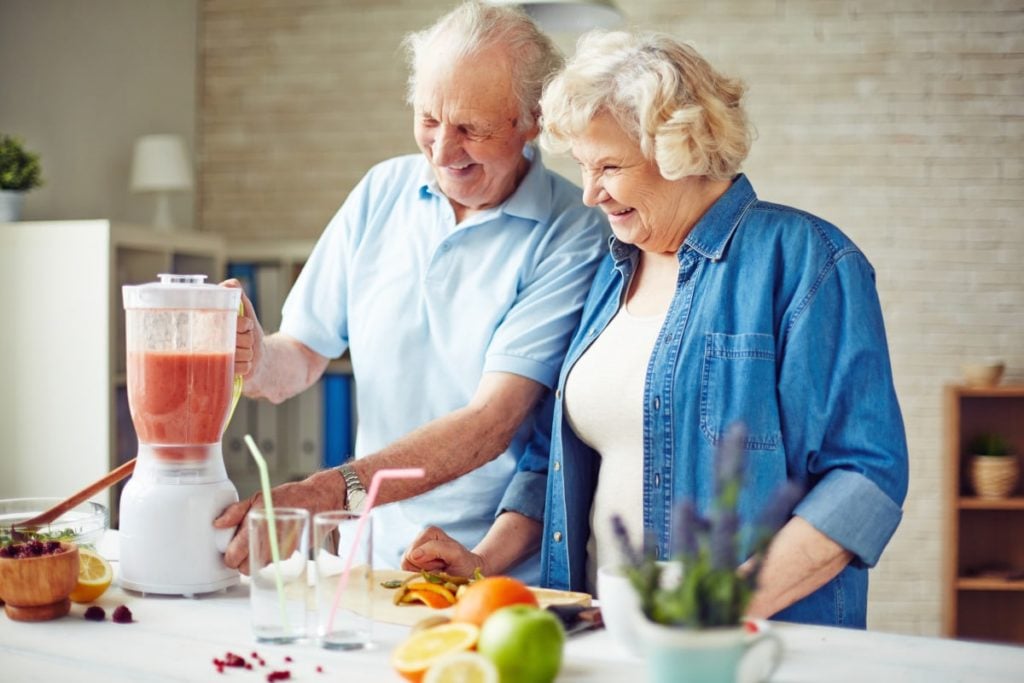 senior couple making fruit smoothie