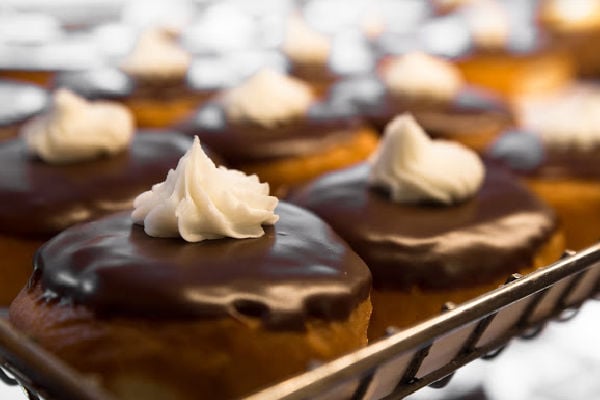 Boston cream donut lined up on a tray