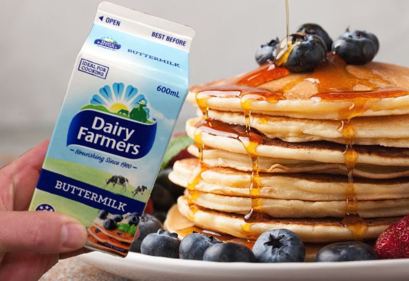 Holding buttermilk next to a stack of pancakes