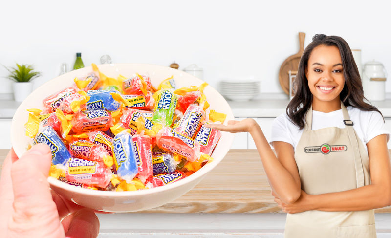 A lady in an apron next to a bowl of Jolly Rancher hard candy