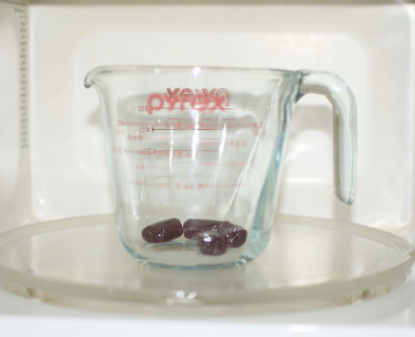 Pyrex jug with hard candies in microwave