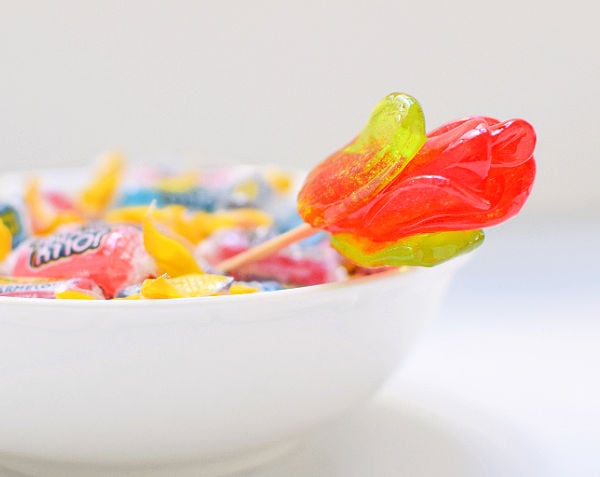 A Rancher Rose in a bowl next to candies.