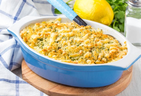 A dish of macaroni cheese on a board