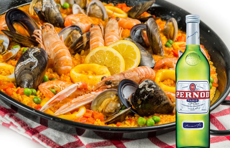 Pernod bottle next to a pan of paella