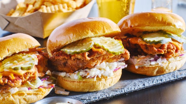 A line of brioche chicken burgers on a plate